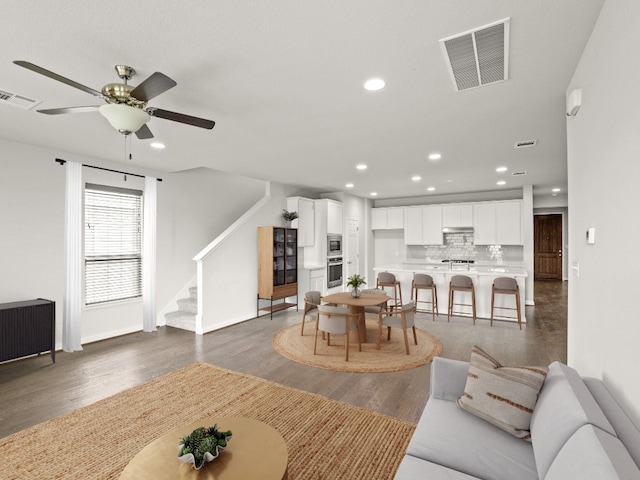 living room featuring dark hardwood / wood-style floors and ceiling fan