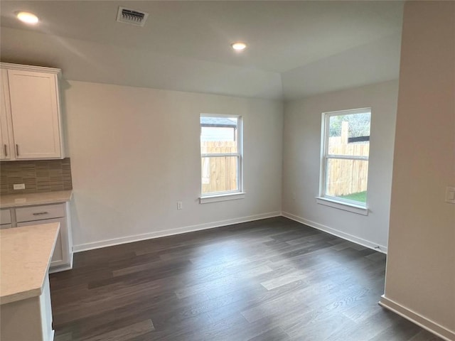 unfurnished dining area with a wealth of natural light and dark wood-type flooring