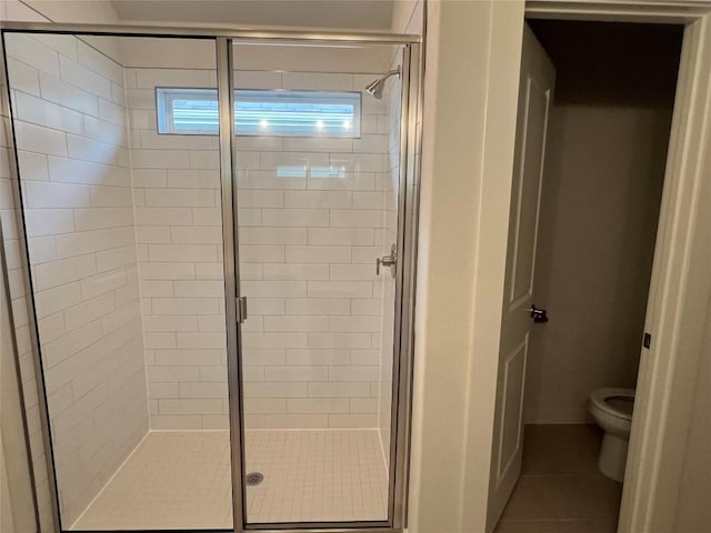 bathroom featuring walk in shower, tile patterned flooring, and toilet