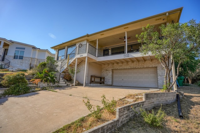 view of front of house with ceiling fan, a garage, and a balcony