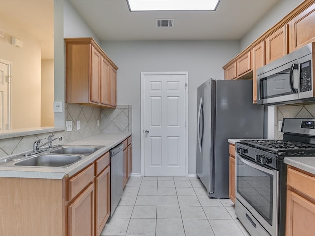 kitchen with decorative backsplash, sink, light tile patterned floors, and stainless steel appliances