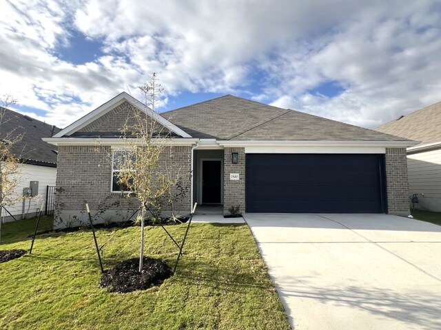 view of front of property with a garage and a front lawn