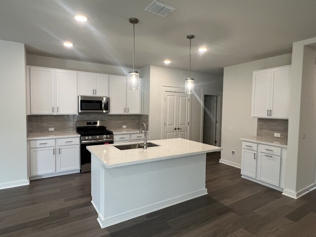 kitchen featuring dark hardwood / wood-style floors, white cabinetry, stainless steel appliances, and hanging light fixtures