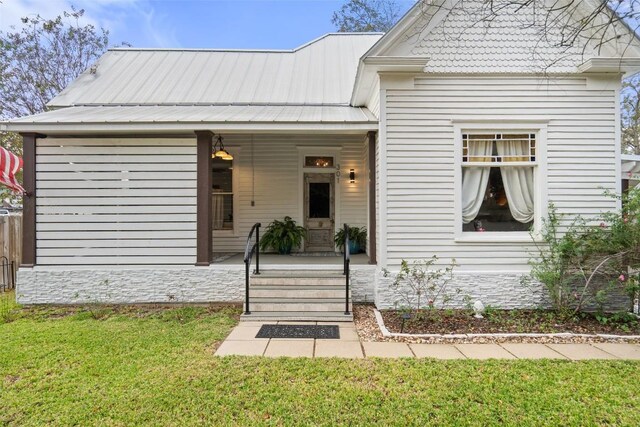 view of front of property featuring covered porch and a front yard