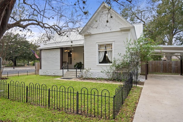 view of front facade with a front yard, metal roof, and a fenced front yard