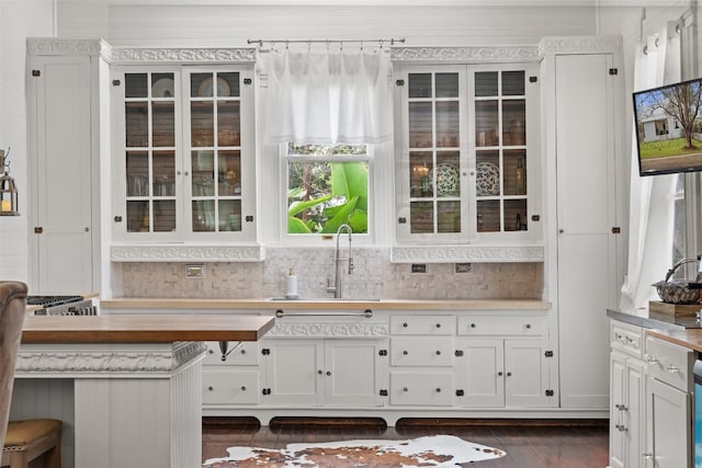 kitchen featuring dark hardwood / wood-style flooring, tasteful backsplash, white cabinetry, and sink