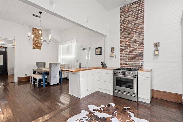 kitchen featuring dark wood-type flooring, kitchen peninsula, stainless steel stove, white cabinetry, and decorative light fixtures