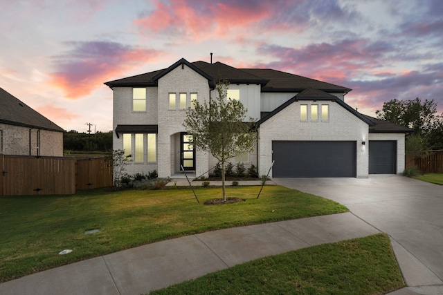 view of front of home with a garage and a yard