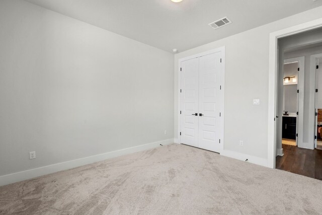 unfurnished bedroom with a closet and carpet flooring