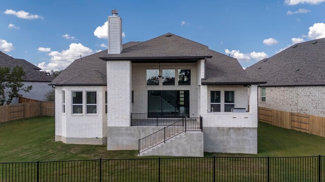 rear view of property with a lawn