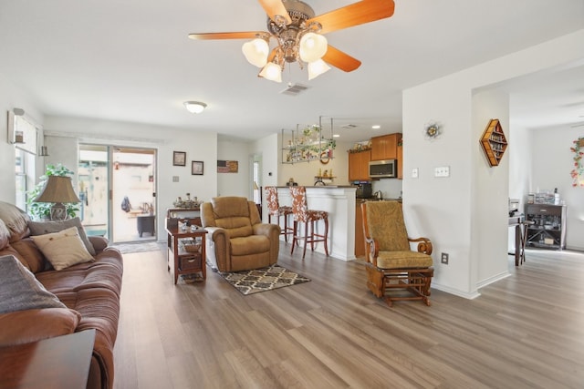 living room featuring light hardwood / wood-style flooring and ceiling fan