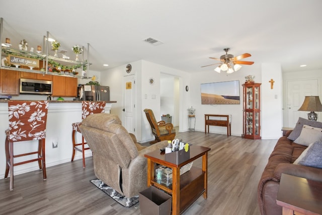 living room featuring hardwood / wood-style flooring and ceiling fan