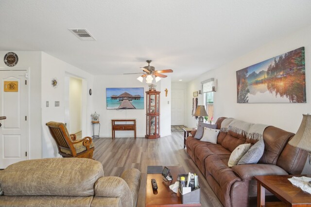 living room featuring light wood-type flooring and ceiling fan