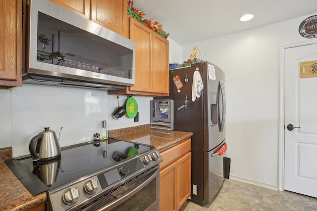 kitchen with dark stone counters and stainless steel appliances