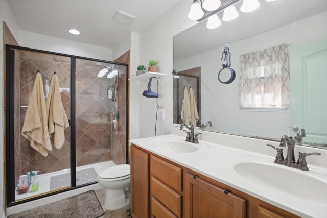 bathroom with toilet, tile patterned floors, vanity, and a shower with door