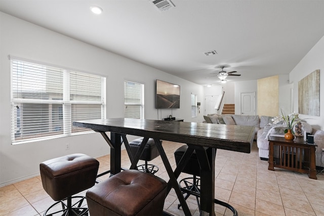 tiled dining area with a wealth of natural light and ceiling fan