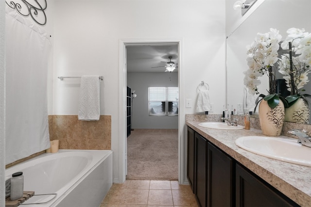 bathroom featuring tile patterned floors, vanity, ceiling fan, and a tub