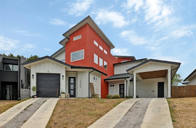 contemporary house featuring board and batten siding, concrete driveway, an attached garage, and fence