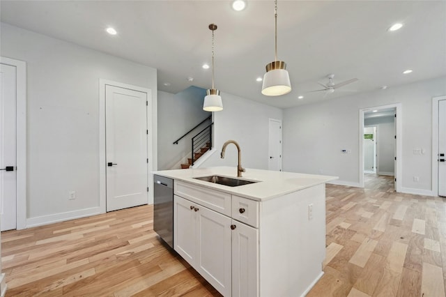 kitchen with pendant lighting, sink, an island with sink, white cabinets, and dishwasher