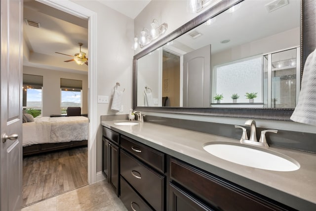 bathroom with walk in shower, vanity, hardwood / wood-style floors, and ceiling fan