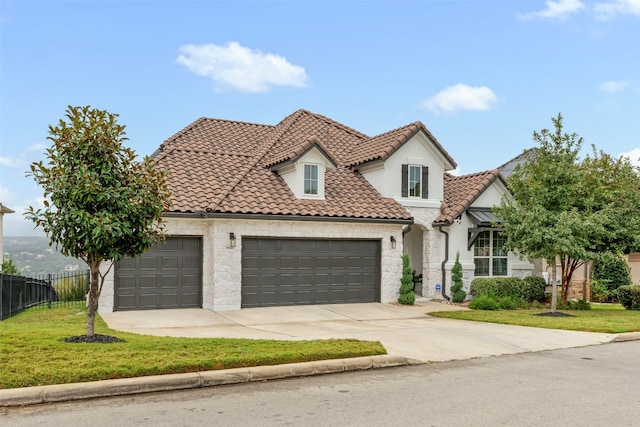 mediterranean / spanish home with a garage and a front yard