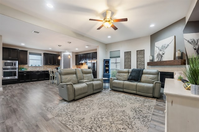 living room with light hardwood / wood-style floors and ceiling fan