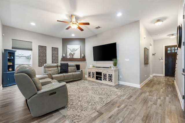 living room featuring light hardwood / wood-style floors and ceiling fan