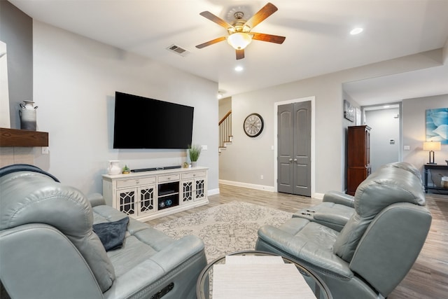 living room with light wood-type flooring and ceiling fan