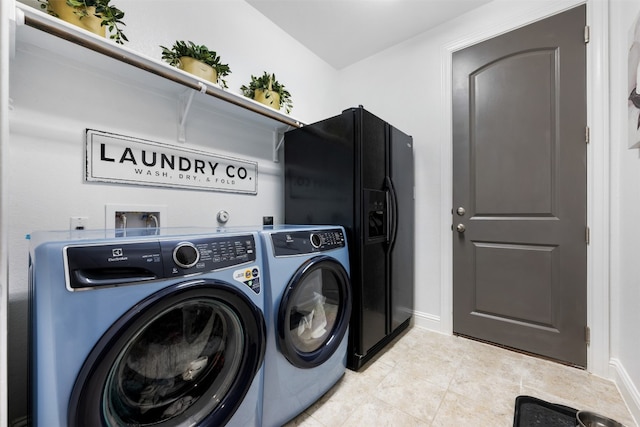 clothes washing area featuring washing machine and clothes dryer and light tile patterned floors