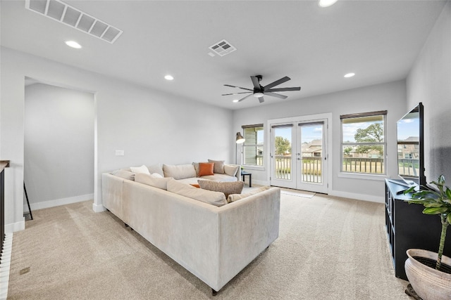 living room with french doors, light colored carpet, and ceiling fan