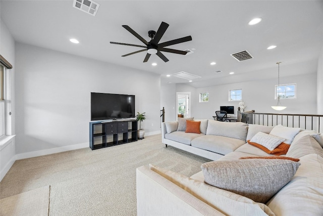 living room featuring ceiling fan, light colored carpet, and plenty of natural light