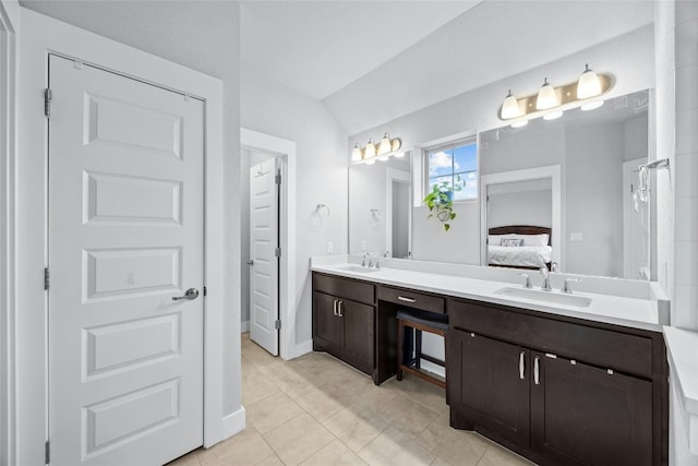 bathroom with vanity, tile patterned floors, and vaulted ceiling