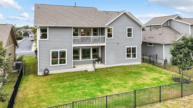 rear view of house featuring central air condition unit, a lawn, a balcony, and a patio area