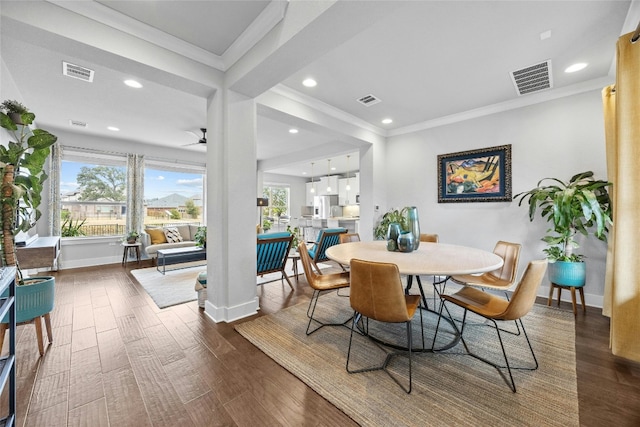 dining space with crown molding and dark hardwood / wood-style flooring