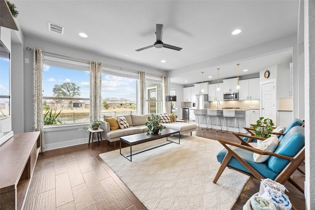 living room featuring ceiling fan, dark hardwood / wood-style floors, and sink