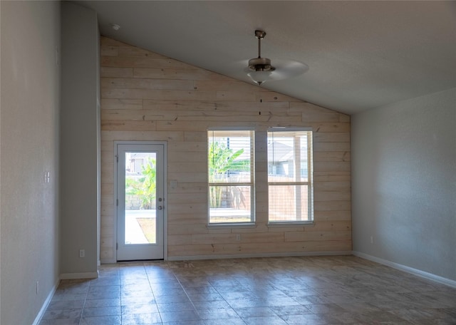 interior space featuring wood walls, lofted ceiling, and ceiling fan