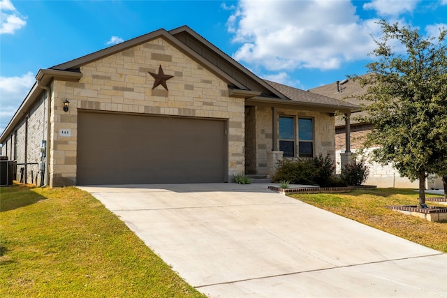 view of front of property with a garage, a front yard, and central AC