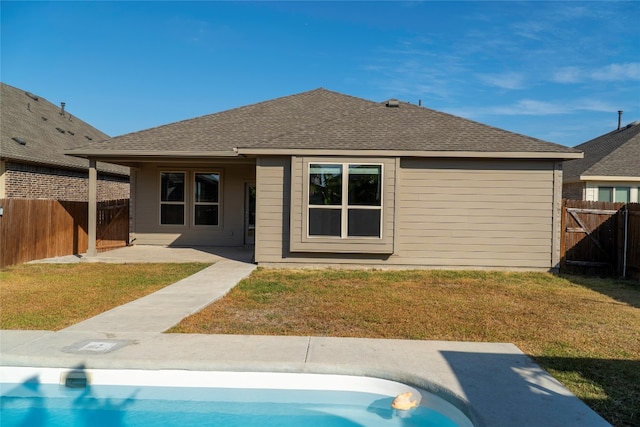 back of house with a patio, a fenced in pool, and a yard