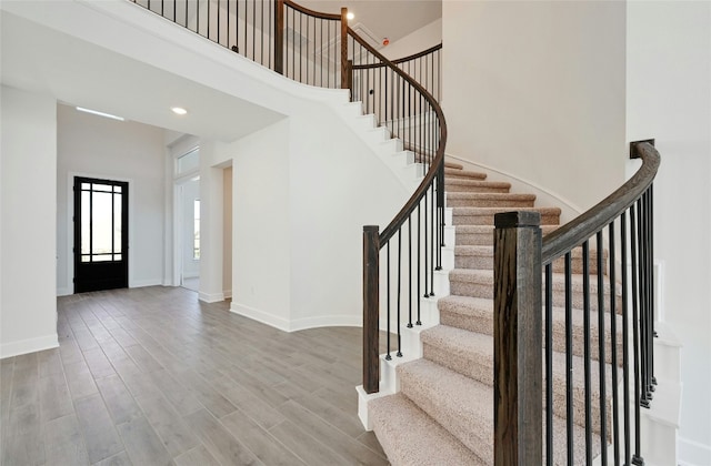 7701 Becasseau Dr, Austin, TX 78738 - foyer featuring a towering ceiling, stairway, and wood finished floors