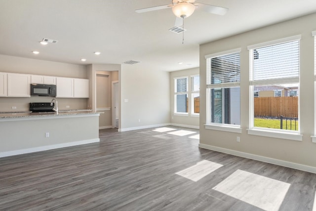 kitchen featuring black appliances, light stone counters, white cabinetry, dark wood-type flooring, and ceiling fan