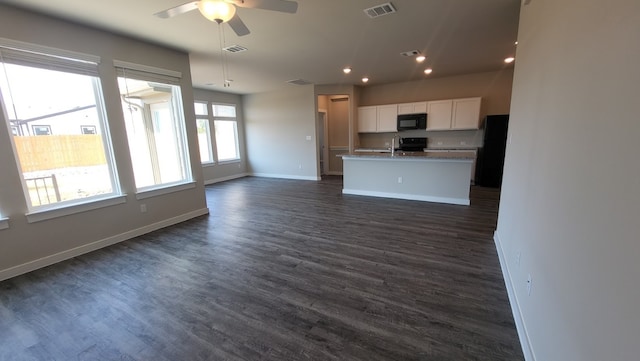 kitchen featuring white cabinetry, sink, a center island with sink, black appliances, and dark hardwood / wood-style flooring