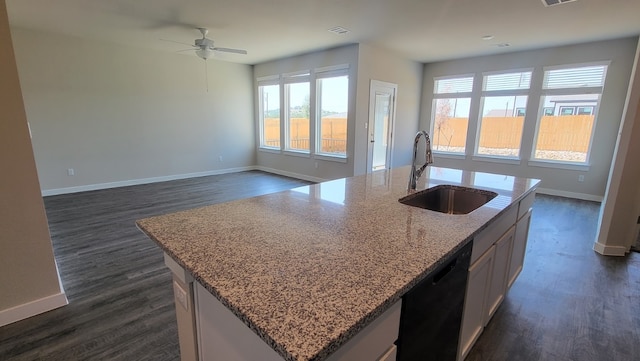 kitchen with dark wood-type flooring, a center island with sink, sink, and dishwasher