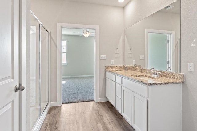 bathroom featuring an enclosed shower, vanity, wood-type flooring, and ceiling fan