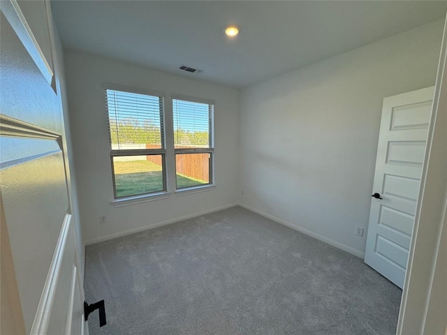 spare room featuring dark carpet