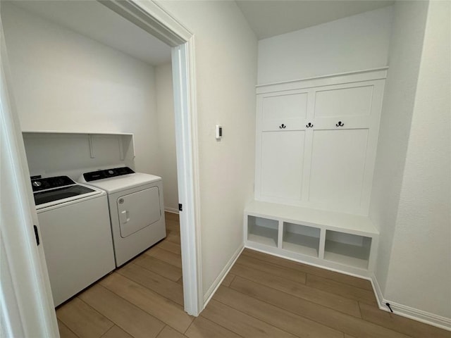 clothes washing area featuring separate washer and dryer and light hardwood / wood-style floors