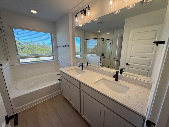 bathroom with vanity, separate shower and tub, and a wealth of natural light