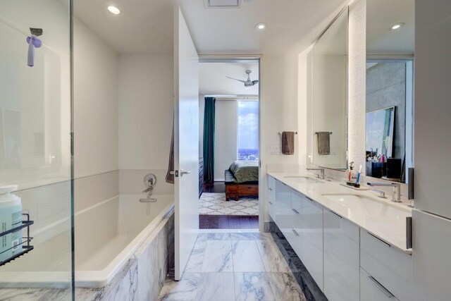 bathroom featuring vanity and tiled bath