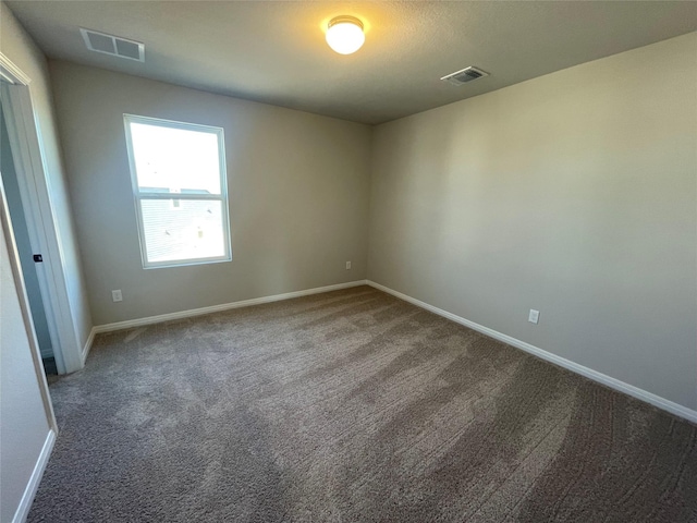 unfurnished room featuring dark carpet