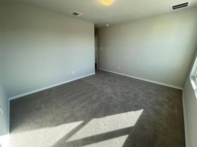 spare room with dark carpet