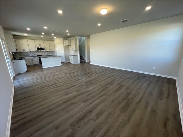 unfurnished living room with sink and dark hardwood / wood-style flooring